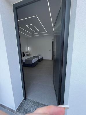 A modern hotel room with a bed, bedside tables, and a ceiling light fixture. - Grand Avelor Hotel (Vlore)