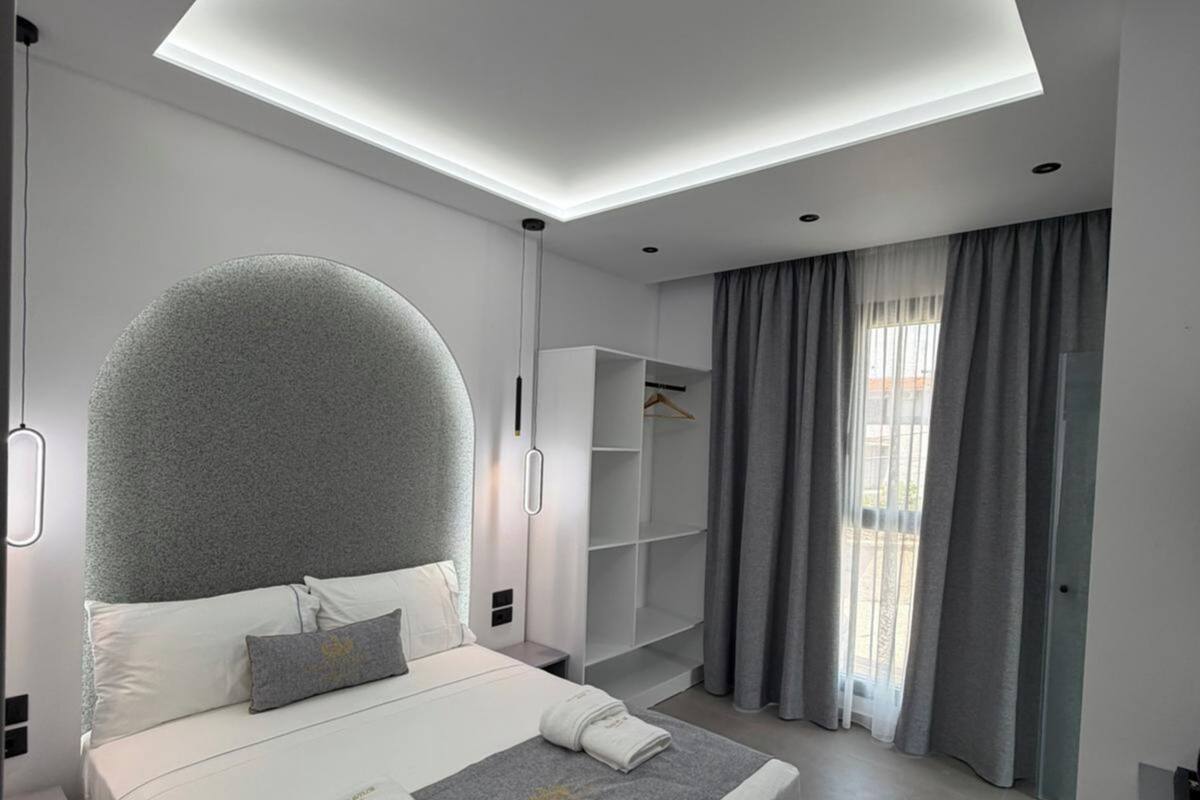 A modern bedroom with a large bed, built-in shelving, and a skylight.