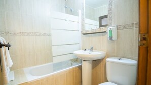 A bathroom with a bathtub, sink, and toilet.