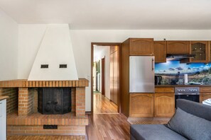 A modern kitchen with wooden cabinets, a built-in oven, and a large window overlooking a scenic landscape. - Apartment 'Haus Behrendt' with Mountain View, Balcony and Wi-Fi (Walkenried)