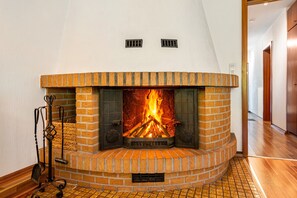 Ein Kamin mit Ziegelverkleidung und ein Metallständer mit einer Schaufel.