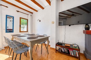 Un coin repas comprenant une table, des chaises et une bibliothèque.