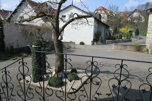 Ein Wohngebiet mit befestigter Auffahrt, einem weißen Haus und einem Baum ohne Blätter.