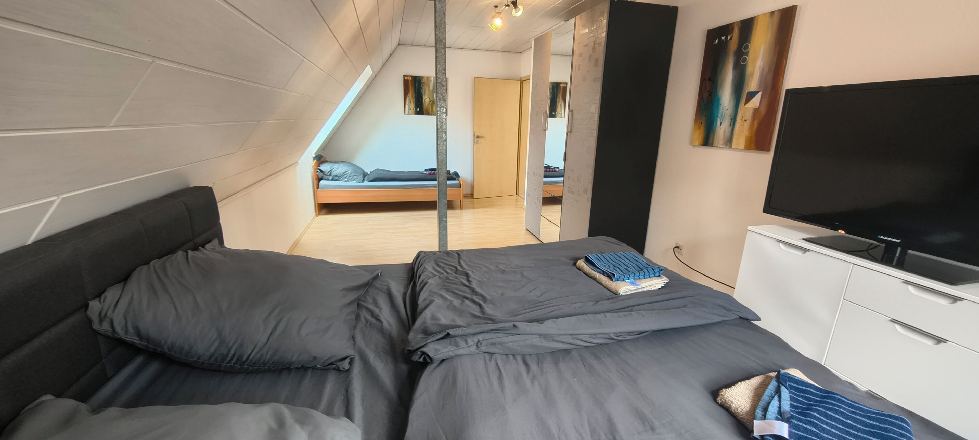 Ein Schlafzimmer mit einem Bett, einem Fernseher und einem Kleiderschrank.