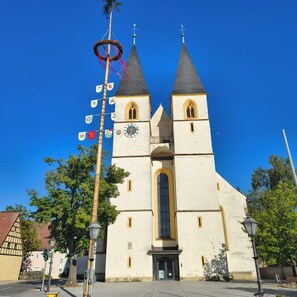 Eine Kirche mit zwei Türmen, einer Uhr und einem Wetterhahn.