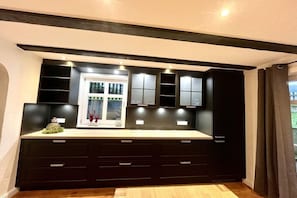 A modern kitchen with dark cabinetry, a window with a view, and built-in lighting. - Holiday home with 2 bedrooms (Olsberg-Elpe)