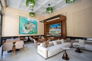 A spacious lobby with a large mural, seating areas, and a bar.