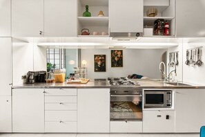 A modern kitchen with white cabinetry, a built-in oven, a microwave, and a gas stove. - Poolside Studio Retreat Near Oxford Street (Sydney)