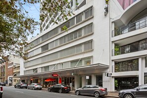 A multi-story building with a modern architectural design, featuring balconies and large windows. - Poolside Studio Retreat Near Oxford Street (Sydney)