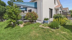 A modern house with a covered patio, a small garden, and a clear sky. - House with garden, 7 adults 1 child (Saint-Michel-Chef-Chef)