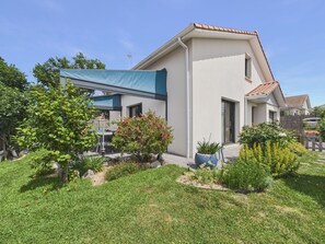 A modern house with a covered patio, a small garden, and a clear sky. - House with garden, 7 adults 1 child (Saint-Michel-Chef-Chef)