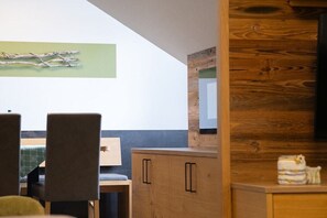 Ein Essbereich mit Stühlen, einem Tisch und einem Holzschrank.