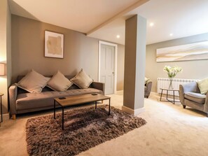 A living room with a sofa, coffee table, and a rug. - Blacksmiths Retreat (York)