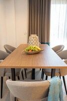 Una mesa de comedor con una cesta de frutas, una vela y un florero.