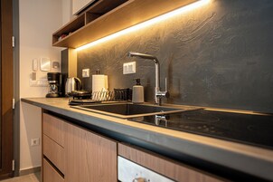 Una cocina moderna con horno empotrado, fregadero y cafetera.