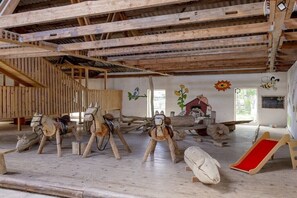 A rustic room with wooden beams, a wooden staircase, and a slide.