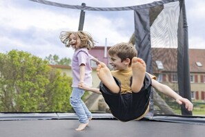 Children playing on a trampoline.