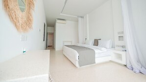 A modern bedroom with a bed, bedside tables, a mirror, and a ceiling light. - One Ocean Apartments  by Nest&Nomad (Msambweni)