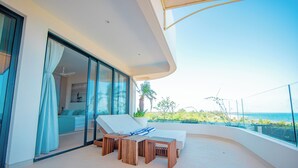 A balcony with a bed, a table, and a chair, overlooking the ocean. - One Ocean Apartments  by Nest&Nomad (Msambweni)