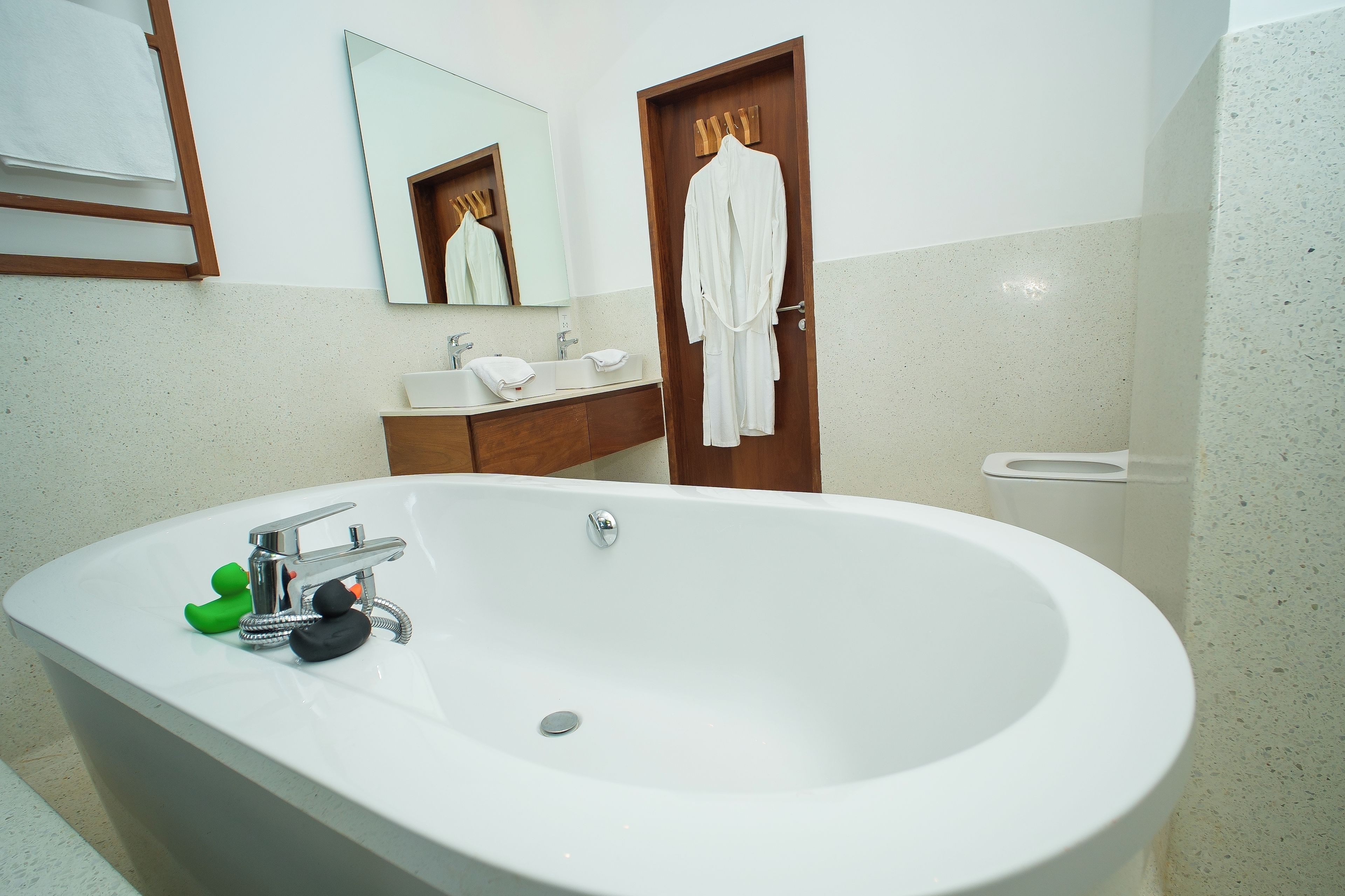 A bathroom with a large bathtub, a sink, and a mirror.