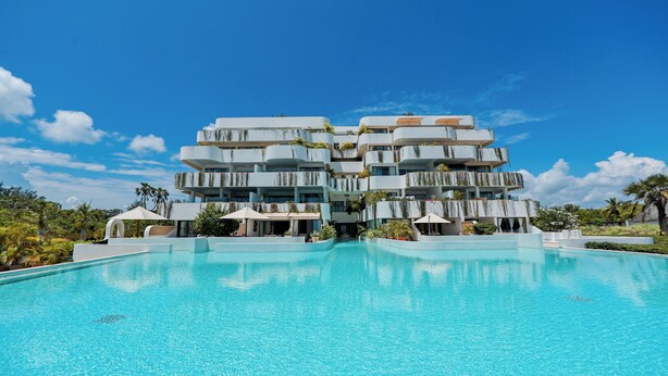 A multi-story hotel with a swimming pool in front. - One Ocean Apartments  by Nest&Nomad (Msambweni)