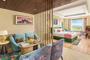 Habitación de hotel con sofá, cama, escritorio y vistas al exterior.