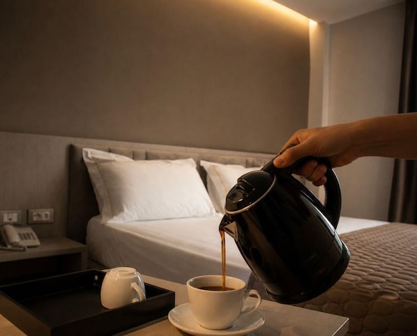 A hand pouring coffee into a cup on a hotel room table. - Rodi Hotel Elbasan (Elbasan)