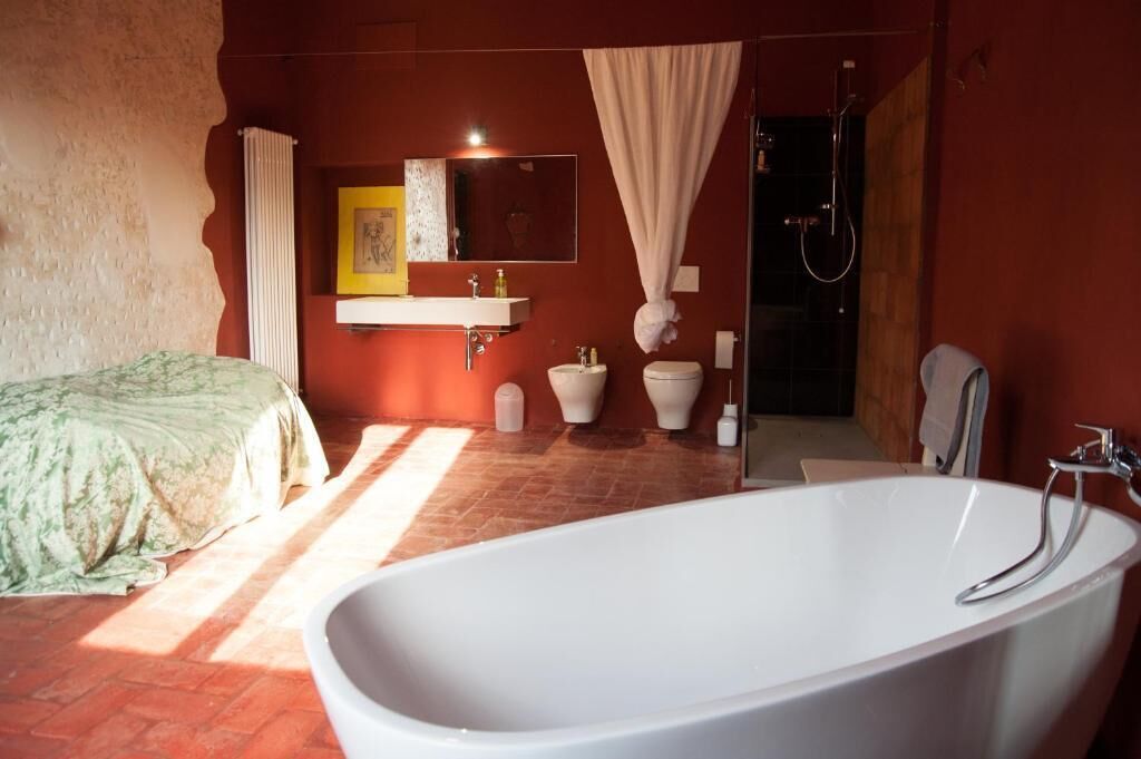 Une salle de bain équipée d’une baignoire, de toilettes, d’un lavabo et d’une douche.