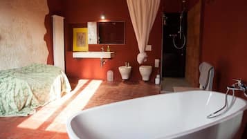 Une salle de bain équipée d’une baignoire, de toilettes, d’un lavabo et d’une douche.