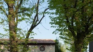 A building with a covered entrance, gravel pathway, and trees. - Corte Mantovanella (Porto Mantovano)
