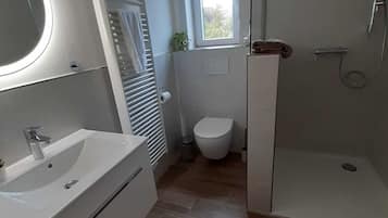 Een douche, een haardroger, handdoeken, toiletpapier