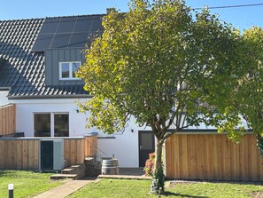 A residential building with a tiled roof, a wooden fence, and a tree in the yard. - Vacation home Widdertshäuschen, apartment Hermann train connection Trier, Saarbrücken (Serrig)