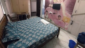 A bedroom with a bed, wardrobe, and a wall-mounted TV. - Aala Homestay (Palayankottai)