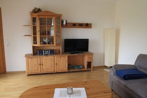 A living room with a wooden cabinet, a television, a sofa, and a coffee table. - 2 in the Kolbe country house (Norden)