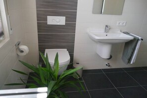 Ein Badezimmer mit Toilette, Waschbecken und Spiegel.