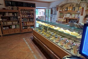 Eine Bäckerei mit einer Auslage an Backwaren und Regalen voller verpackter Produkte.