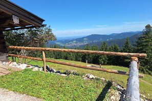 Ein Holzzaun mit Blick auf eine gebirgige Landschaft.
