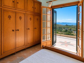 Un dormitorio con un armario grande, una cama y un balcón con vistas.