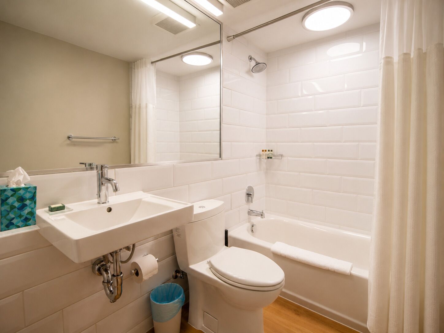 A modern bathroom with a white sink, toilet, and bathtub.