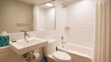 A modern bathroom with a white sink, toilet, and bathtub.