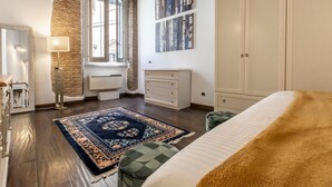 Ein Schlafzimmer mit einem großen Bett, einem Schminktisch, einem Spiegel, einer Heizung und einem Fenster mit Blick.