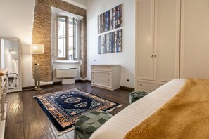 Ein Schlafzimmer mit einem großen Bett, einem Schminktisch, einem Spiegel, einer Heizung und einem Fenster mit Blick.