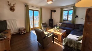 Ein Wohnzimmer mit Kamin, einer Couch, einem Couchtisch und einem Fernseher.
