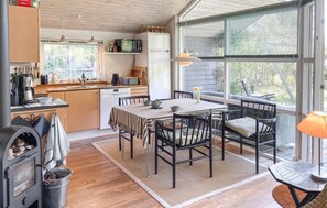 Eine gemütliche Küche mit Essbereich, Holzböden und großen Fenstern.