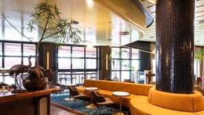 A modern interior with a large black column, seating areas, and a large window providing natural light. - High-Rise 2-Bed Stay at Queensbridge (Southbank)