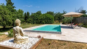A swimming pool with a Buddha statue, a wooden deck, and a covered area with lounge chairs. - Bed and Breakfast 'Chambre Merlot' with Shared Pool, Shared Terrace and Wi-Fi (Saint-Germain-du-Puch)