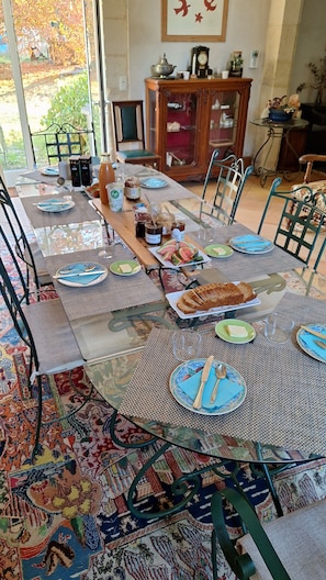 Un comedor con una larga mesa dispuesta para una comida, rodeada de sillas.