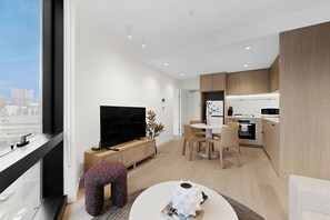 A modern living room with a TV, seating, and a dining area. - Southbank 2-Bed - Swepping City Views, Pool & Gym (Southbank)