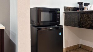 A compact kitchen with a microwave and refrigerator, a countertop with a coffee maker, and a tiled floor. - 1 King Bed|Non-Smoking, Micfridge (Oakland)