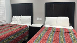 A hotel room with two beds, each with a dark headboard and white bedding. There is a small black nightstand between the beds. - 2 Full Beds|Nsmk, Micfridge (Oakland)